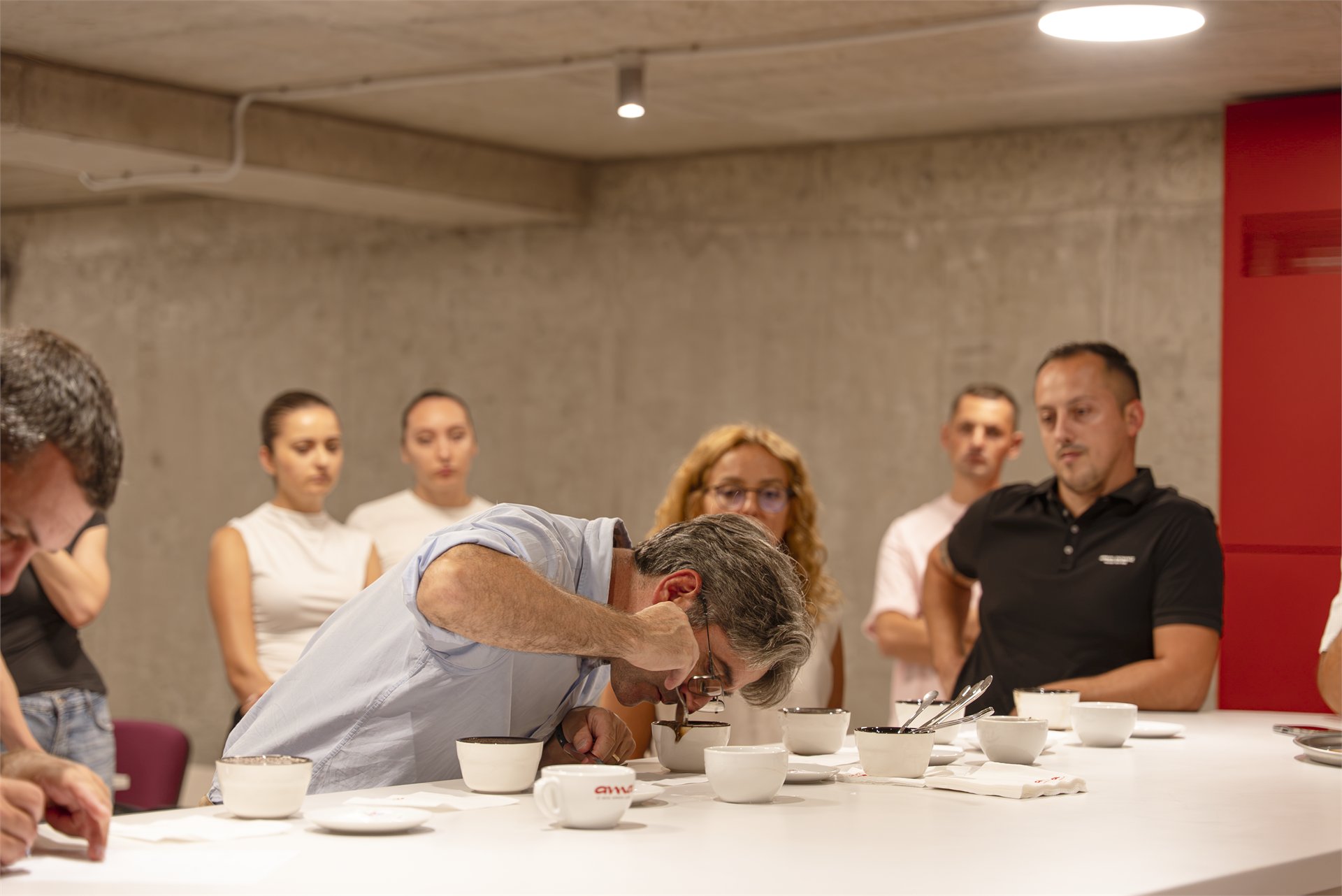 Trainer smelling coffee during cupping