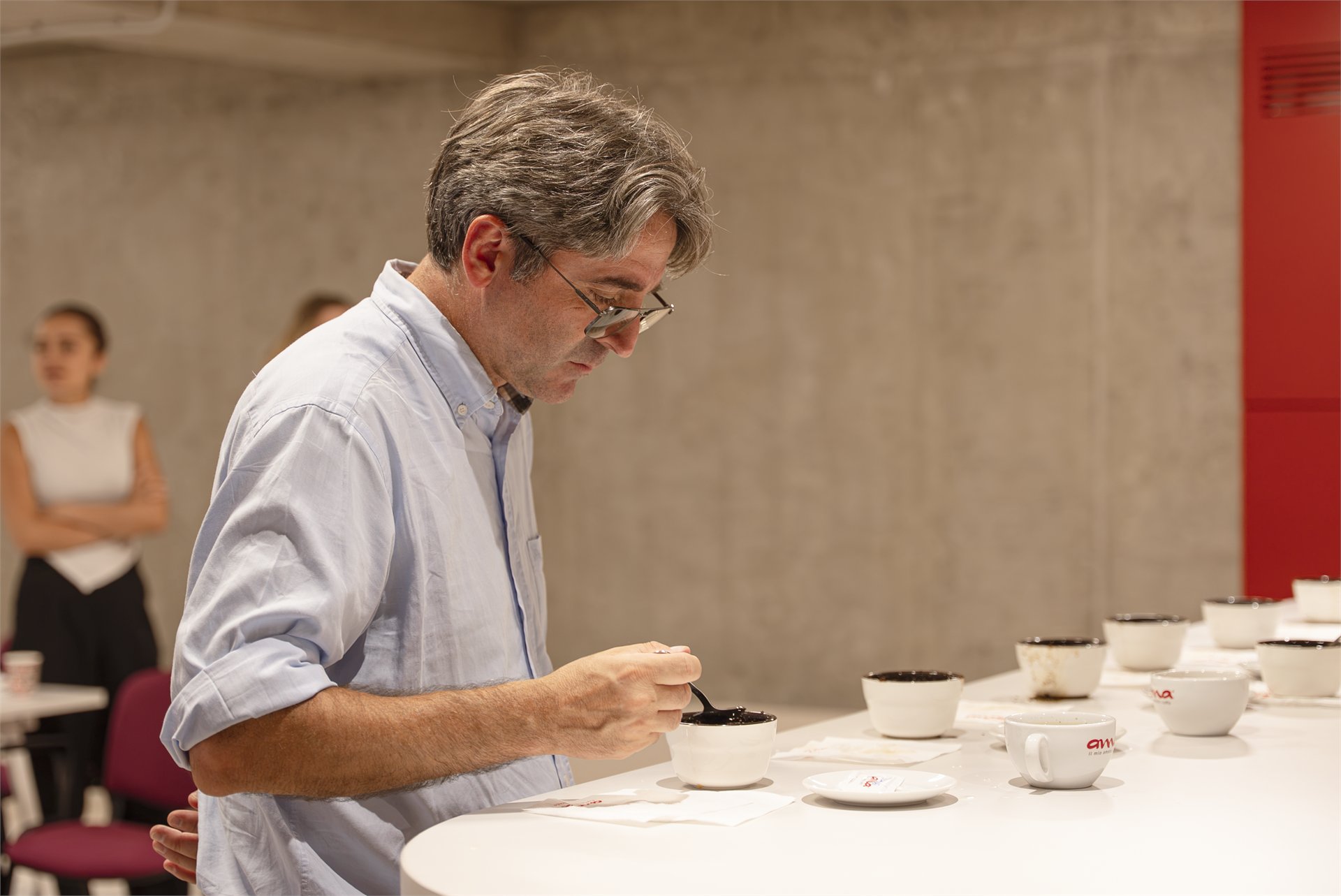 Trainer evaluating coffee sample